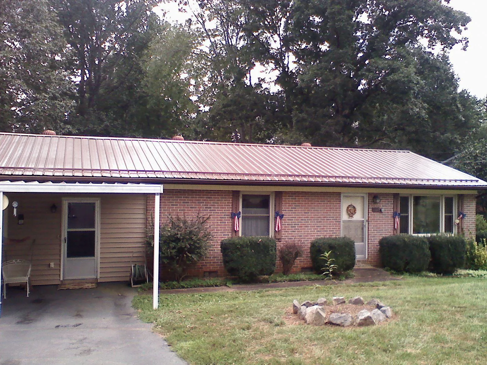 Bronze metal roof and carport on a brick ranch home — Roof Repair work by our crew in Newton Upper Falls